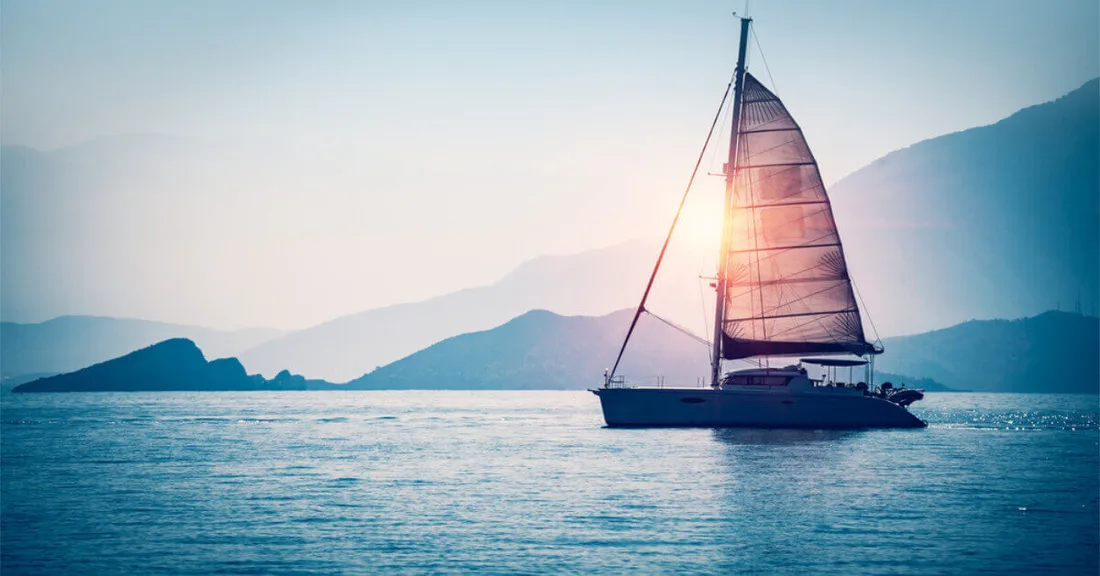 Reference photograph of a small sailboat on calm water at dusk.